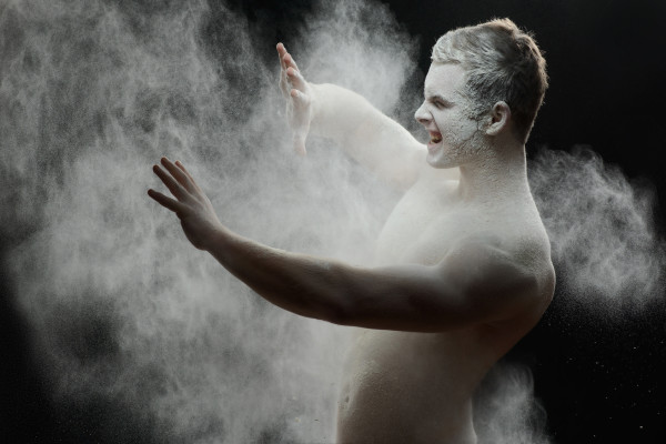 Handsome frozen man with a white powder on his body